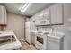 Galley-style kitchen with white appliances, tile floors and ample counter space at 2151 Clearwater Dr. # C, Surfside Beach, SC 29575