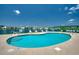Inviting community pool with lounge chairs and serene views of the lake and surrounding condos at 2151 Clearwater Dr. # C, Surfside Beach, SC 29575