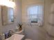 Bright bathroom featuring a modern sink, toilet, mirror, and natural light from the window at 223 Greentown Rd., Georgetown, SC 29440