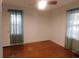 Sunlit bedroom with neutral walls, hardwood floors, and decorative curtains around the windows at 223 Greentown Rd., Georgetown, SC 29440