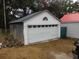 Detached garage with white siding and a large roll-up door at 223 Greentown Rd., Georgetown, SC 29440