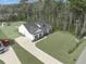 An aerial view of a white house with black shutters, a long drive and expansive lawn at 250 Ole Maple St., Loris, SC 29569