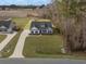 Aerial view of a home with a long driveway and a large front yard with green grass and trees in the background at 250 Ole Maple St., Loris, SC 29569