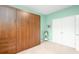 Bedroom featuring a wooden murphy bed with built-in storage, complemented by soft green walls and neutral carpet at 250 Ole Maple St., Loris, SC 29569