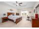 Spacious bedroom with tray ceiling, ceiling fan, large bed, and dedicated desk workspace at 250 Ole Maple St., Loris, SC 29569