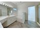 Bright bathroom featuring double sinks, a large mirror with Hollywood lights, and a marble-trimmed tub at 270 Georgetown Dr., Pawleys Island, SC 29585