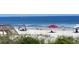 Sunny beach with blue water and people relaxing under canopies at 270 Georgetown Dr., Pawleys Island, SC 29585