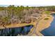 Aerial view of a home on a lake with mature trees, landscaping, and scenic golf course views at 3178 River Bluff Ln., Little River, SC 29566