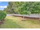 Well-maintained back yard featuring a mature tree, lush lawn, and a white picket fence at 322 Crooked Oak Dr., Pawleys Island, SC 29585