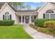 Inviting front entrance featuring a covered porch with decorative columns and manicured shrubbery at 3471 Spivey St., Loris, SC 29569