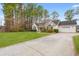 View of home featuring well-maintained landscaping, a paved driveway, and an attached two-car garage at 3471 Spivey St., Loris, SC 29569