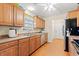 Traditional kitchen features wooden cabinetry, stainless steel appliances, laminate flooring, and natural light at 3471 Spivey St., Loris, SC 29569