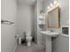 Neutral-toned half bathroom with a pedestal sink, wall mirror, and convenient storage shelves for essentials at 3567 Marion Ln., Murrells Inlet, SC 29576