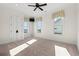 Bright bedroom with neutral carpet, a ceiling fan, and three windows offering natural light and waterfront view at 3567 Marion Ln., Murrells Inlet, SC 29576