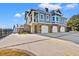 Spacious four-car garage beneath a charming home featuring a raised foundation and lovely blue siding at 3567 Marion Ln., Murrells Inlet, SC 29576