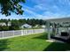 Green backyard with white fence and a covered patio with seating at 378 Thistle Ln., Myrtle Beach, SC 29579