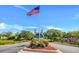 Welcoming Avalon entrance with US flag, beautiful landscaping, and gatehouse, under a clear sky at 378 Thistle Ln., Myrtle Beach, SC 29579