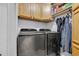 Modern laundry room with stainless steel washer and dryer and wood cabinetry at 378 Thistle Ln., Myrtle Beach, SC 29579