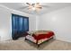 This bedroom has carpeted floors, a ceiling fan, and a large window with blue curtains at 4612 Red Bluff Rd., Loris, SC 29569