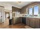 Well-lit kitchen with wooden cabinets, black dishwasher, and a view from the window at 4612 Red Bluff Rd., Loris, SC 29569