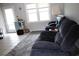 Cozy living room with a plush grey recliner, a soft rug, and natural light from the windows at 4649 Tarpon Bay Rd., Myrtle Beach, SC 29579