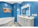 Stylish bathroom with blue accents, a soaking tub, and a vanity with white cabinets at 4956 Dory Ct., North Myrtle Beach, SC 29582