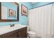 Bathroom featuring blue walls, a shower with a white curtain, and an elegant vanity at 4956 Dory Ct., North Myrtle Beach, SC 29582