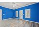 Bright bedroom with blue walls, light wood-look floors, white trim, and a ceiling fan at 4956 Dory Ct., North Myrtle Beach, SC 29582