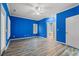 Spacious blue bedroom with white trim, wood floors, and natural light from windows at 4956 Dory Ct., North Myrtle Beach, SC 29582