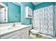 A full bathroom with a turquoise walls, white vanity and matching linen storage cabinet at 5046 Belleglen Court # 101, Myrtle Beach, SC 29579