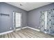 This bedroom features a large window with modern curtains, neutral paint, and wood-look flooring at 5046 Belleglen Court # 101, Myrtle Beach, SC 29579