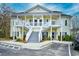 Attractive yellow condo building featuring white stairs and well-maintained landscaping in a community setting at 5046 Belleglen Court # 101, Myrtle Beach, SC 29579