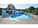 Community pool area featuring a pool, clubhouse, lounge chairs, and tables at 5046 Belleglen Court # 101, Myrtle Beach, SC 29579