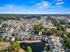 Aerial view of community with pond and swimming pool under a bright, blue sky at 5070 Windsor Green Way # 204, Myrtle Beach, SC 29579