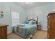 Cozy bedroom features soft blue walls, a comfortable bed, and bright natural light from the window at 5070 Windsor Green Way # 204, Myrtle Beach, SC 29579