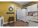 Bright kitchen features white appliances and cabinets, granite countertops, and view of pantry at 5070 Windsor Green Way # 204, Myrtle Beach, SC 29579