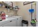 Functional laundry room featuring a washer, dryer, and shelving for storage at 5070 Windsor Green Way # 204, Myrtle Beach, SC 29579