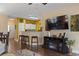 Cozy living room with bar stool seating open to the kitchen area and a modern entertainment center at 5070 Windsor Green Way # 204, Myrtle Beach, SC 29579