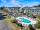 Aerial view of community pool and seating area, adjacent to the main building and parking at 5070 Windsor Green Way # 204, Myrtle Beach, SC 29579