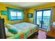 Inviting bedroom with bright yellow walls, offers ocean views, and sliding glass door leading to a private balcony at 5905 S Kings Hwy. # 1801-C, Myrtle Beach, SC 29575