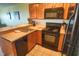 A cozy kitchen featuring wooden cabinetry, black appliances, and a convenient breakfast bar for casual dining at 5905 S Kings Hwy. # 1801-C, Myrtle Beach, SC 29575