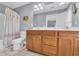 Well-lit bathroom with double sinks, tile flooring, and a shower/tub combination with shell-themed curtain at 624-B Seabreeze Dr., Garden City Beach, SC 29576