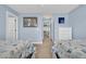 Charming bedroom featuring twin beds with white frames and soft blue walls and neutral colored carpet at 624-B Seabreeze Dr., Garden City Beach, SC 29576