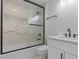 Modern bathroom featuring marble tile, sleek black fixtures, and a glass-enclosed shower over the bathtub at 6606 Wildwood Trail # D, Myrtle Beach, SC 29572