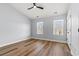 Light-filled bedroom with hardwood floors, a ceiling fan, and two windows providing ample natural light at 6606 Wildwood Trail # D, Myrtle Beach, SC 29572