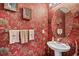 Charming powder room with tropical-themed wallpaper, decorative mirror, and pedestal sink at 677 Wilshire Ln. # 677, Murrells Inlet, SC 29576