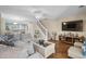 Well-lit living room with a TV, fireplace, comfortable sectional sofa, and staircase to the upper level at 677 Wilshire Ln. # 677, Murrells Inlet, SC 29576