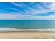 A beach view of clear blue ocean, white sand, blue skies, and soft waves at 6900 N Ocean Blvd. # 1536, Myrtle Beach, SC 29572