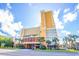 A lovely view of this multi-story resort with palm trees, street view, and bright blue skies at 6900 N Ocean Blvd. # 1536, Myrtle Beach, SC 29572