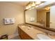 Bathroom featuring a double sink vanity with granite countertops, decorative mirror, and storage at 8121 Amalfi Pl. # 4-702, Myrtle Beach, SC 29572